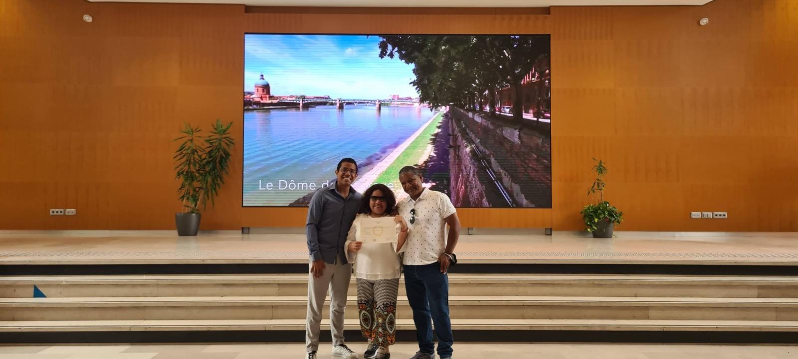 Juan celebrating his economics diploma with his parents